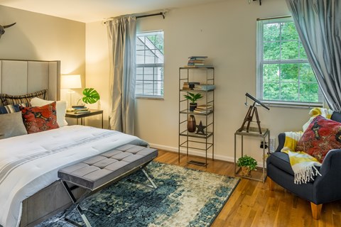 Bedroom with a bed and a couch and two windows at Indian Creek Apartments, Cincinnati